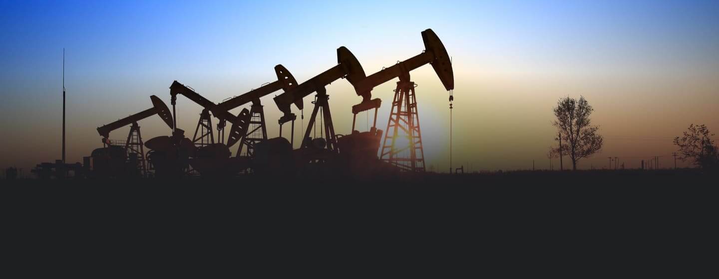 Oil well pumpjacks on the horizon at sunrise